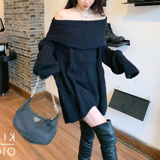 ブラックのニットワンピースを着用した女性の正面。袖を広げた姿と裾の広がりが分かる写真