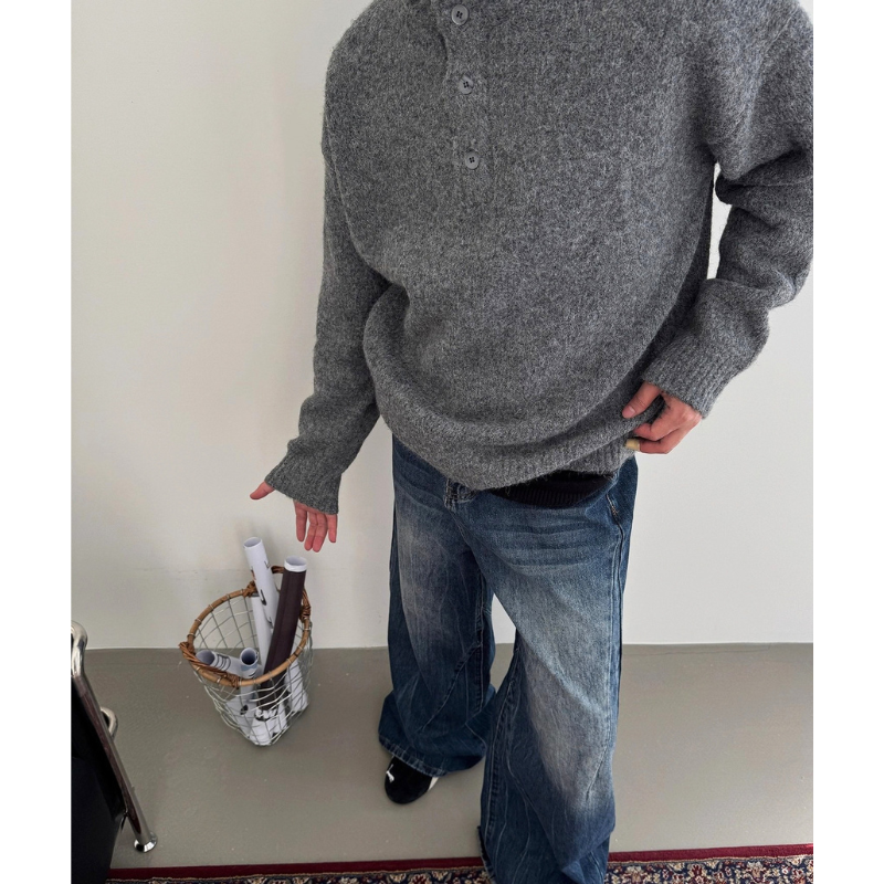グレーのボタン付きモックネックニットプルオーバーを着た男性の編み地と裾のリブが見える斜め上からの着用カット