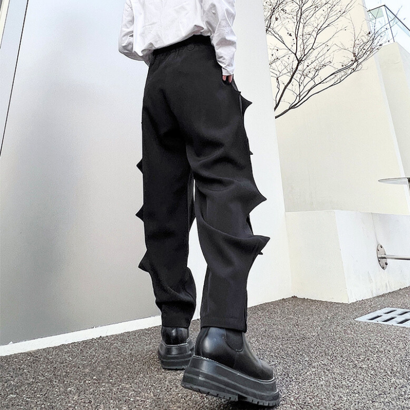 トゲのような凹凸が強調された立体プリーツパンツ、後ろ姿