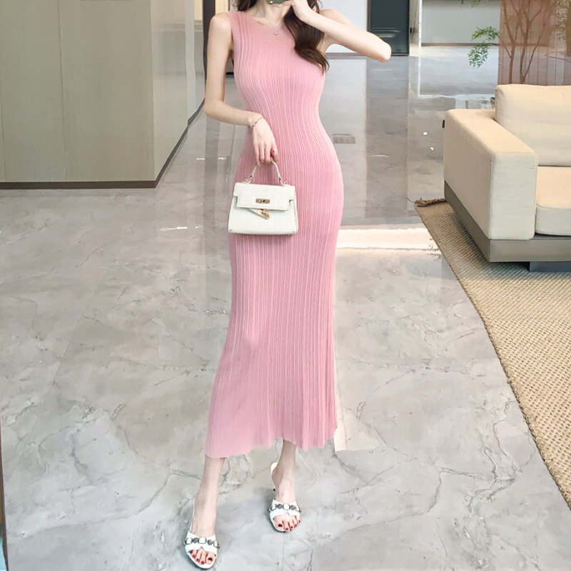 ピンクのリブニットワンピースと白い鞄をコーデした女性