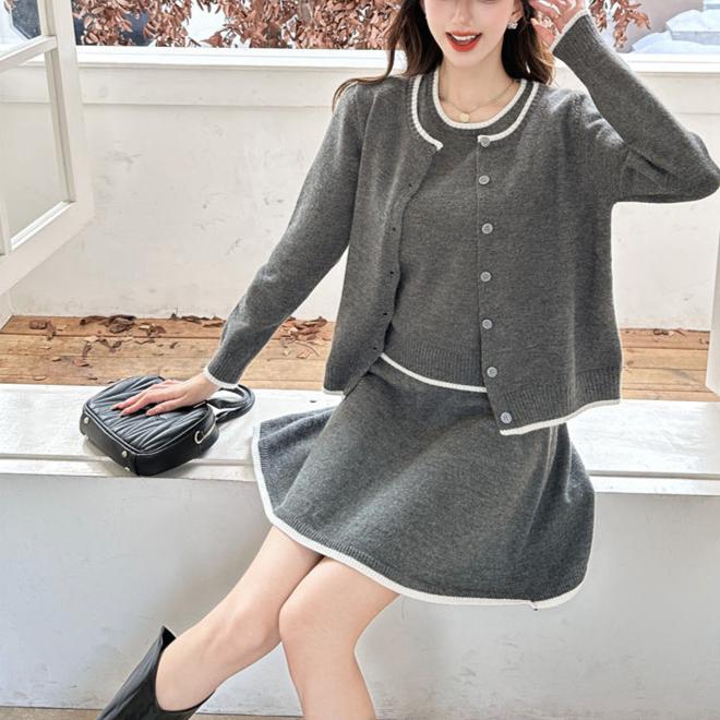 室内で座っているニットセットアップ(グレー)