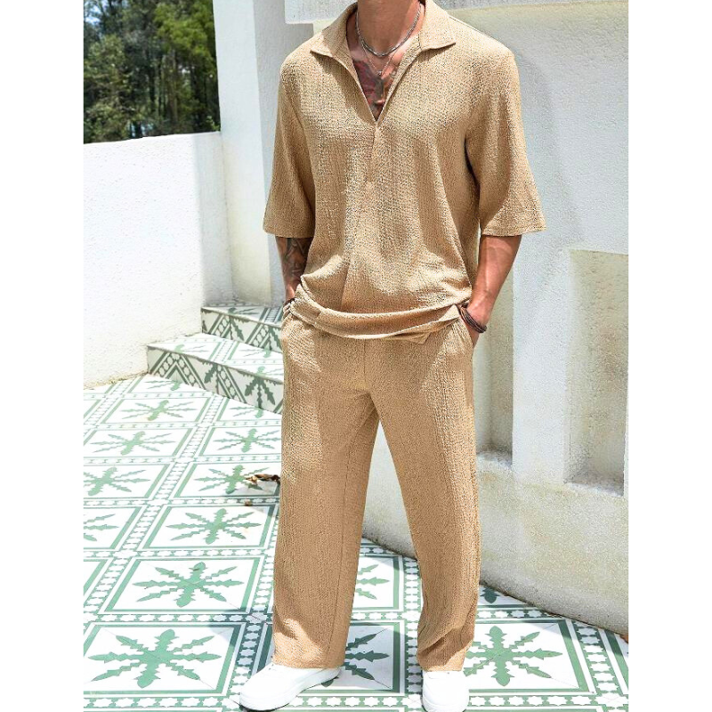 ベージュのセットアップを屋外で着用した男性モデル