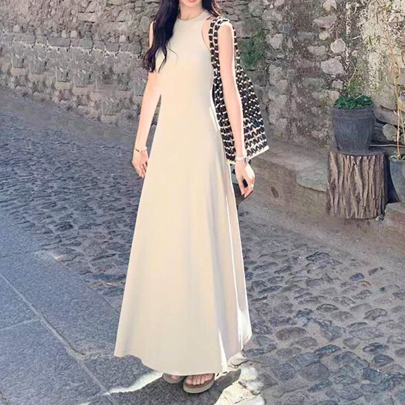 背中のデザインと華奢な肩ラインが映えるベージュワンピ