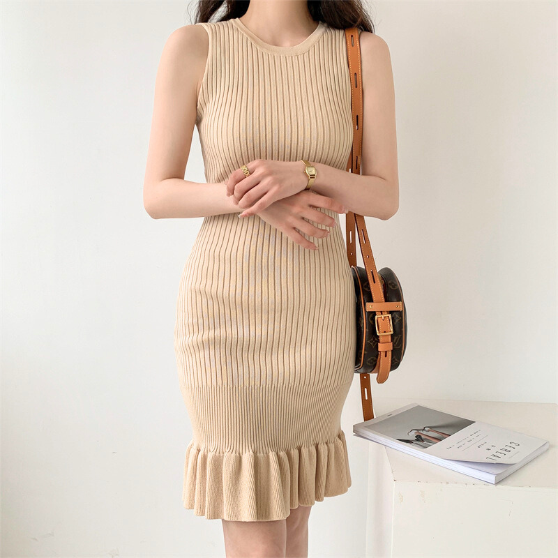 ベージュのフリルニットワンピースで腕を組む着姿