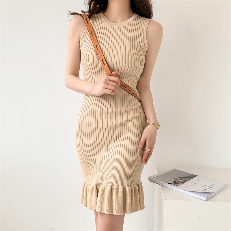 ベージュワンピースを着てポーズする女性