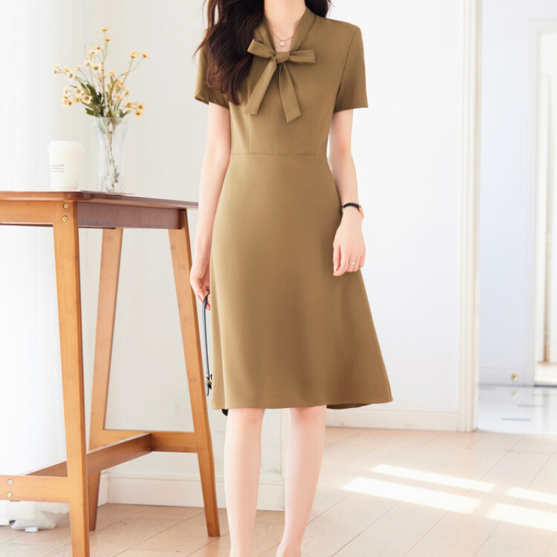 ベージュワンピースで立ち姿を見せる女性