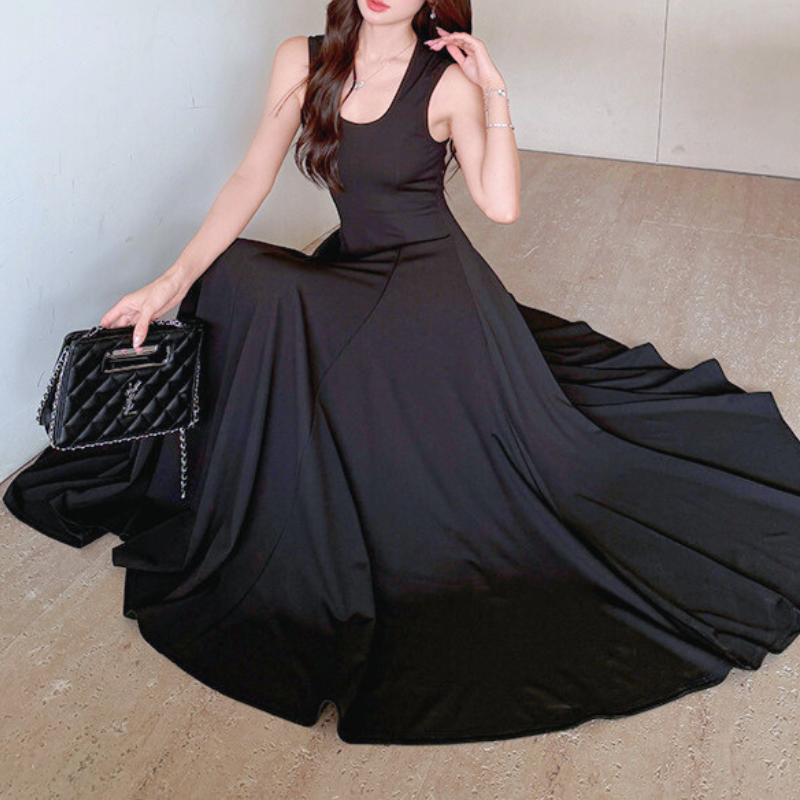 優雅に座ったポーズが映える黒ノースリーブロングワンピース