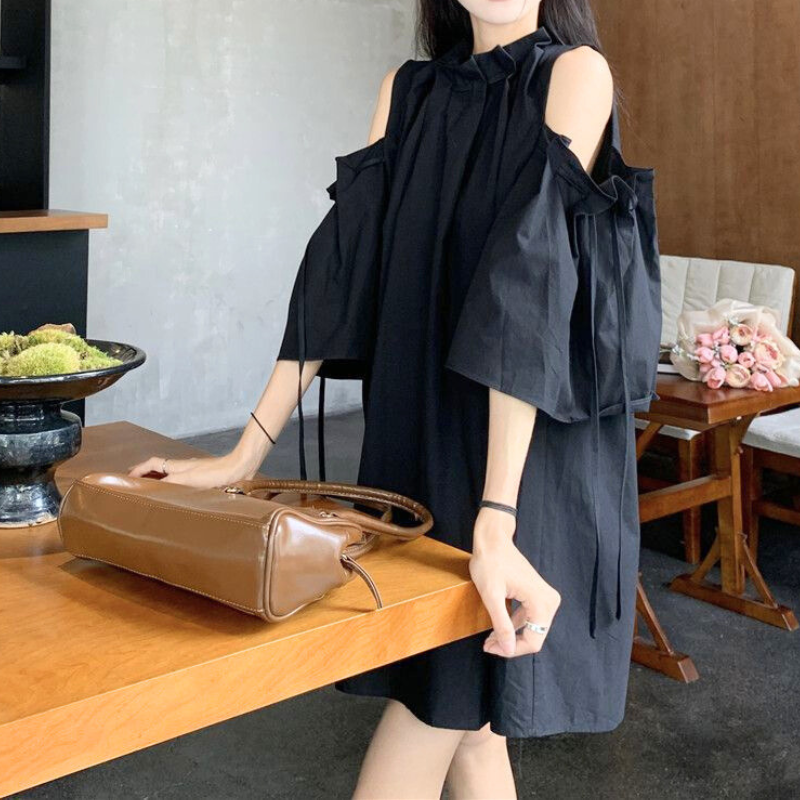 ブラックのワンピースでカフェ風のシーンに映えるスタイル。