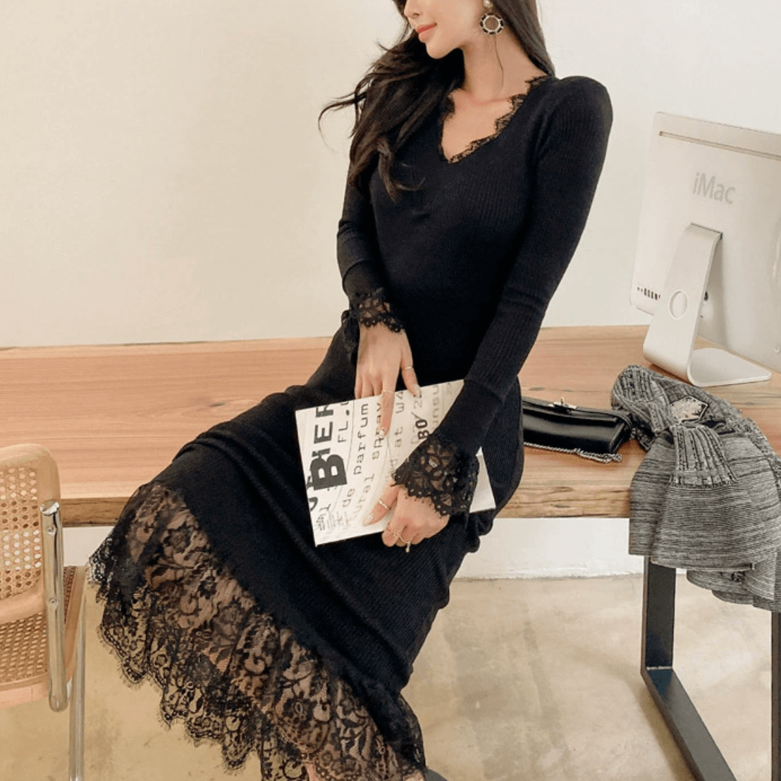 座ってポーズを取るブラックレースワンピースの女性