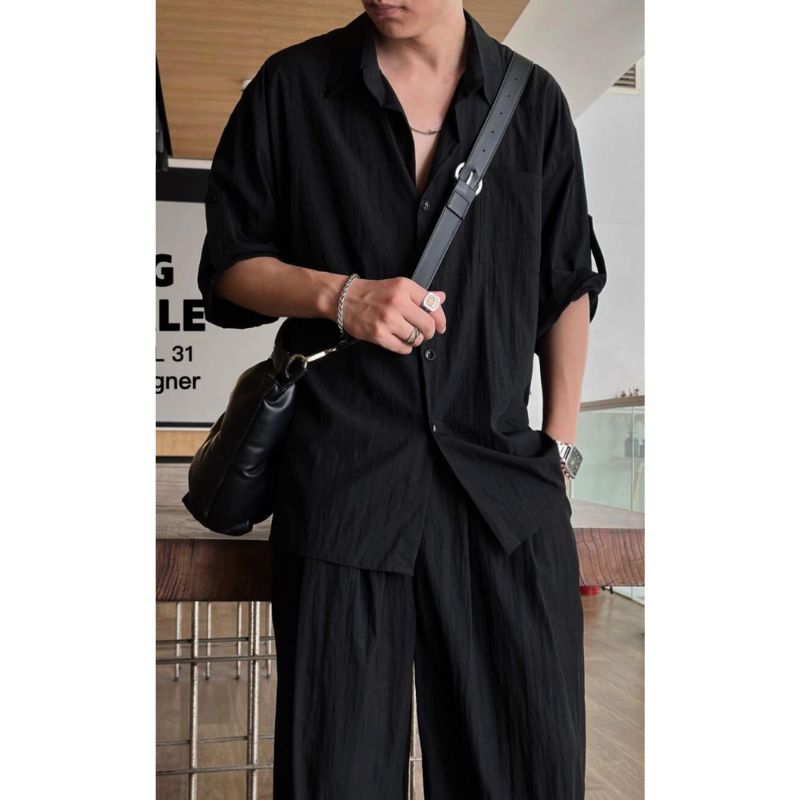 黒セットアップ着用の男性(胸元と腕のアクセ見せ)