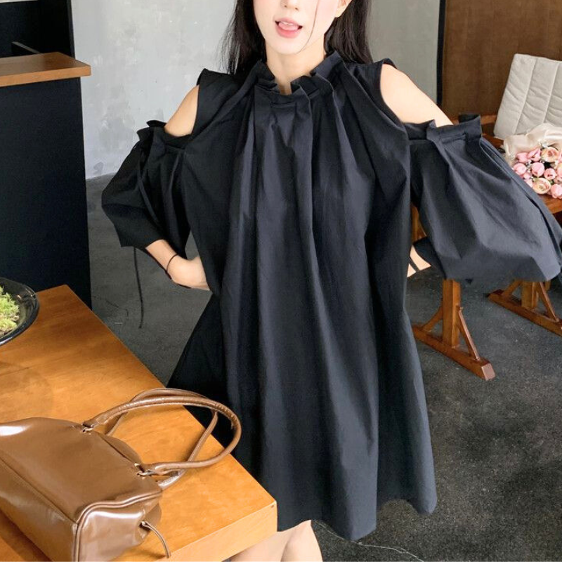 ブラックの肩あきギャザーワンピースを着た女性。大人のモード感を演出。