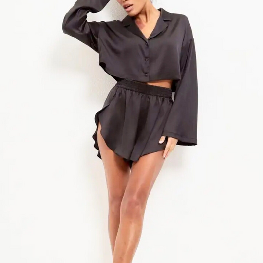 ブラックのとろみサテン風クロップドシャツとラウンドヘムショーツを着た30代女性モデル。おうちデートやお泊まりに似合う大人可愛いルームウェア