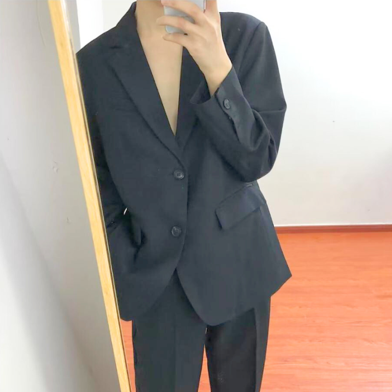 鏡越しに撮影した黒スーツのスマートな着こなし