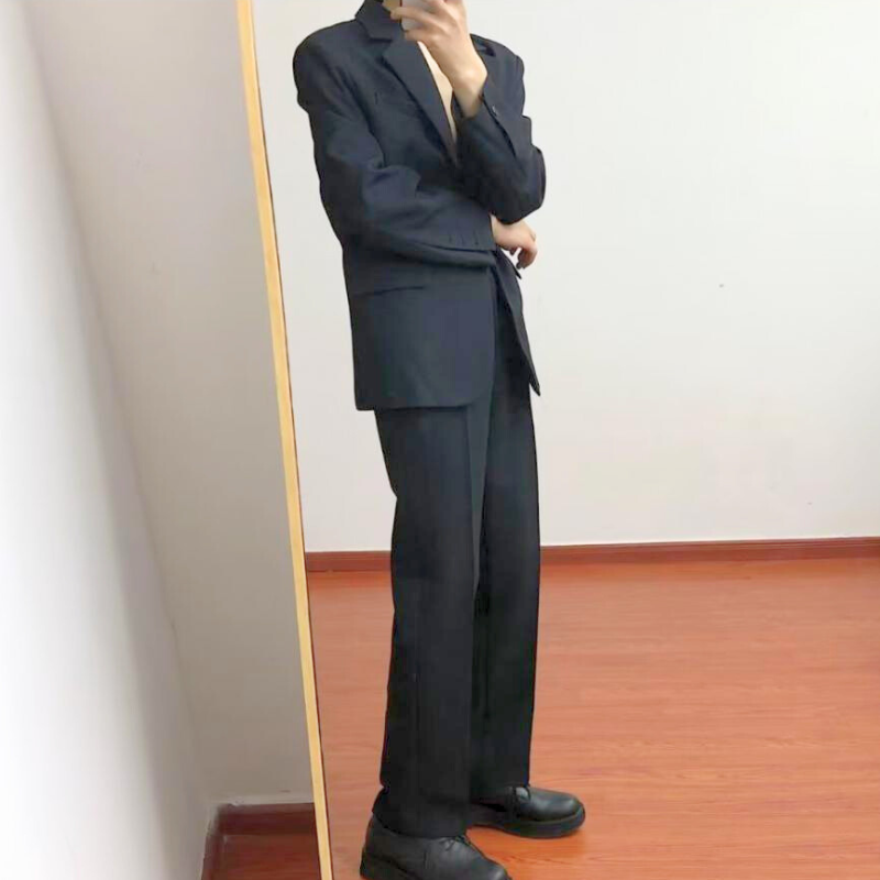 シンプルに立ち姿を見せた黒スーツの全体コーデ