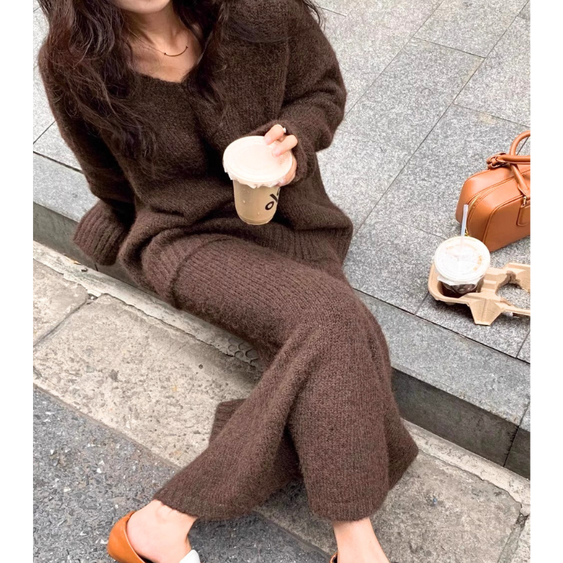 カフェの前で座るブラウンセットアップ姿の女性