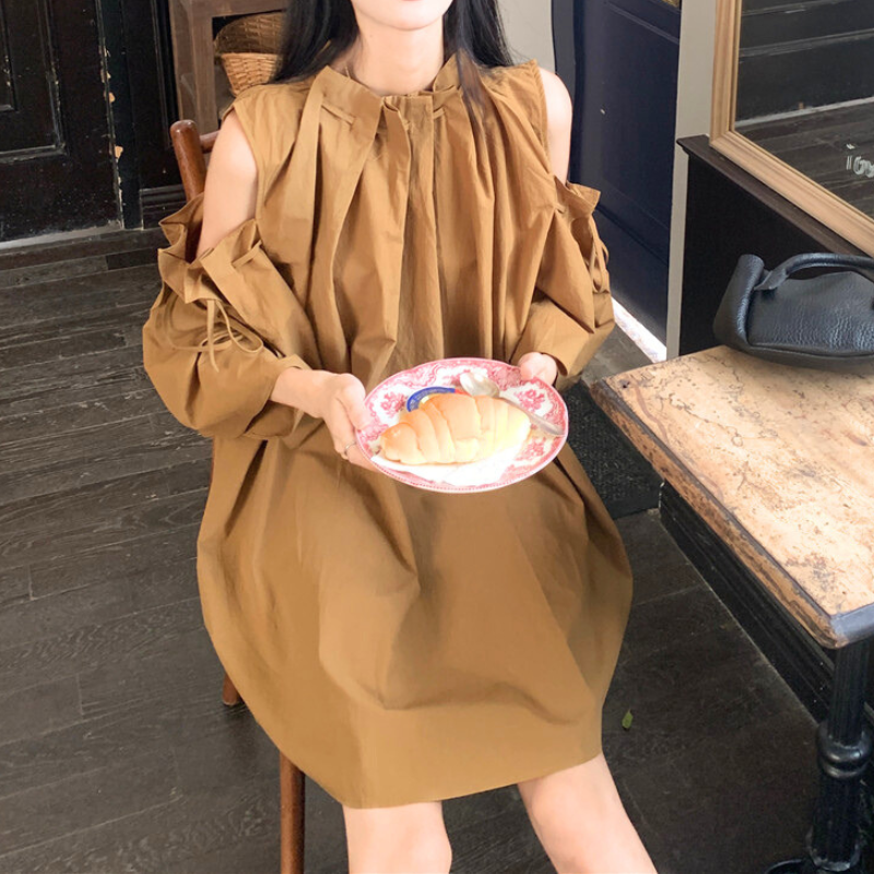 キャメルワンピースを着てスイーツを楽しむ女性。ふんわり袖が印象的な秋コーデ。