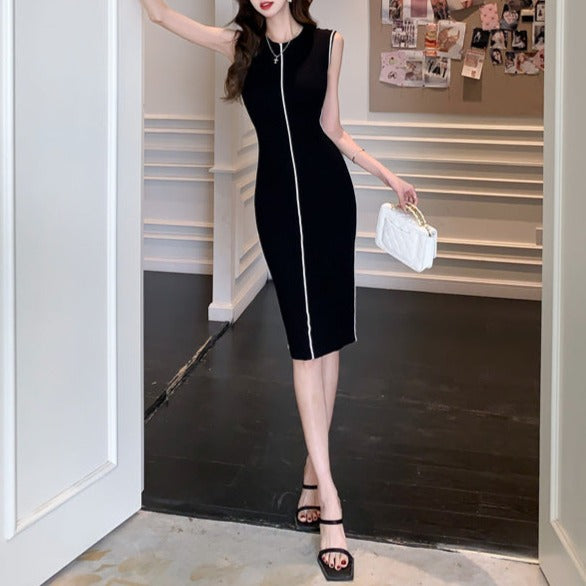 ブラックのリブワンピースにヒールとハンドバッグを合わせ、洗練されたモノトーンコーデを完成させた女性