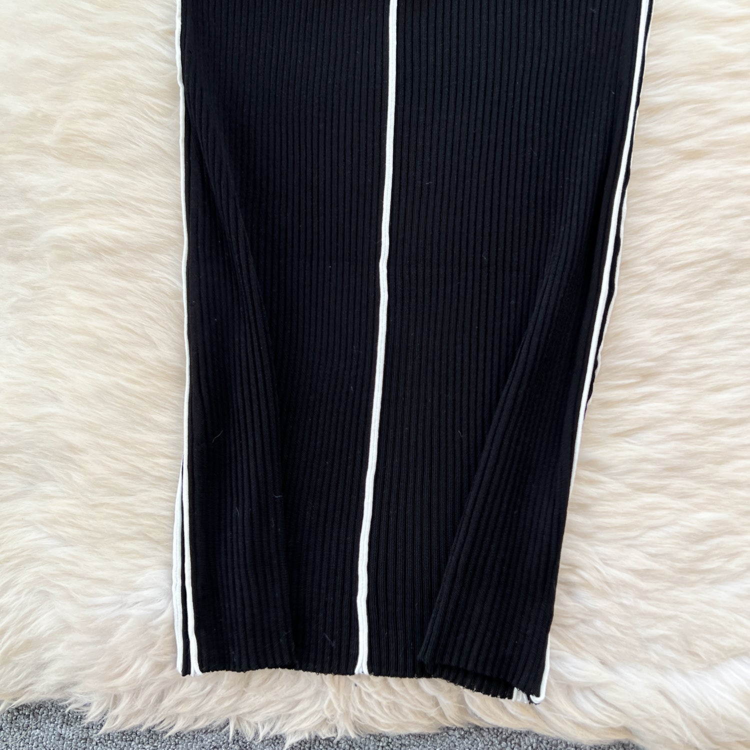 縦リブ素材とホワイトラインをクローズアップ。身体にフィットしやすい伸縮性が特徴のタイトワンピース