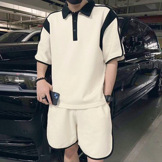 スマホを持った姿でポーズをとる配色ポロシャツ×ハーフパンツスタイル