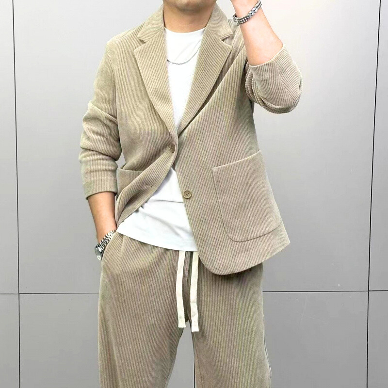 ベージュセットアップを腕まくりでラフに着こなす男性