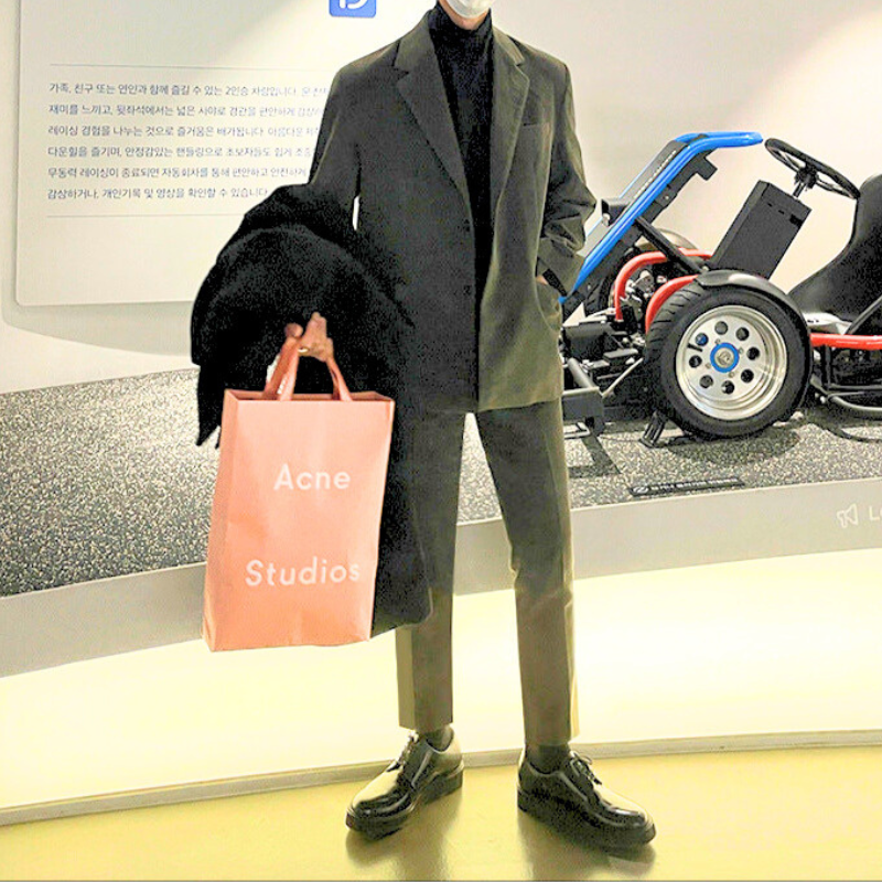 モデルがAcne Studiosバッグを持ってポーズする姿、コーデュロイセットアップで秋冬でも暖かい