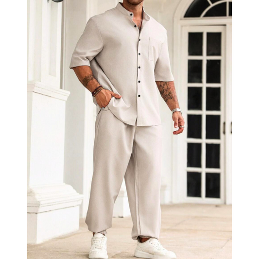 アイボリーのセットアップを着用した男性がサイドに立つ様子