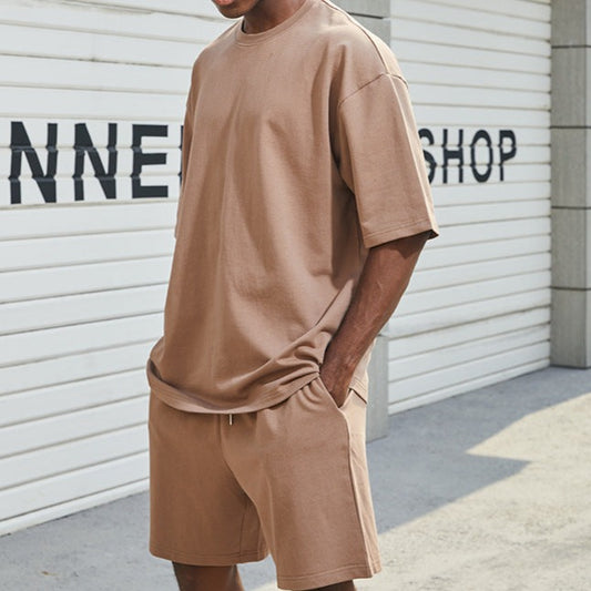 ブラウンの無地コットンセットアップを着た男性の全身スタイル