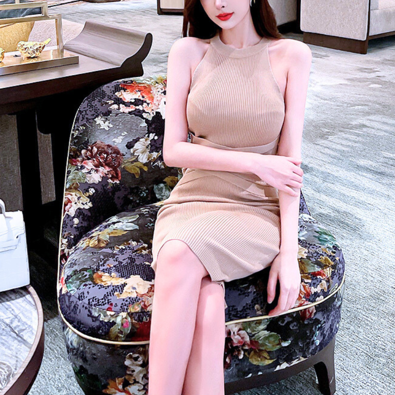 花柄ソファに座るクロスラインニットワンピ姿