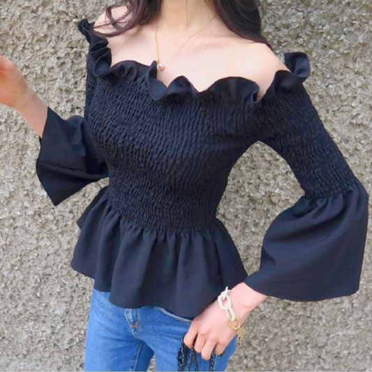 鎖骨が綺麗に見える黒のフリルオフショルブラウスを着た女性の上半身アップ