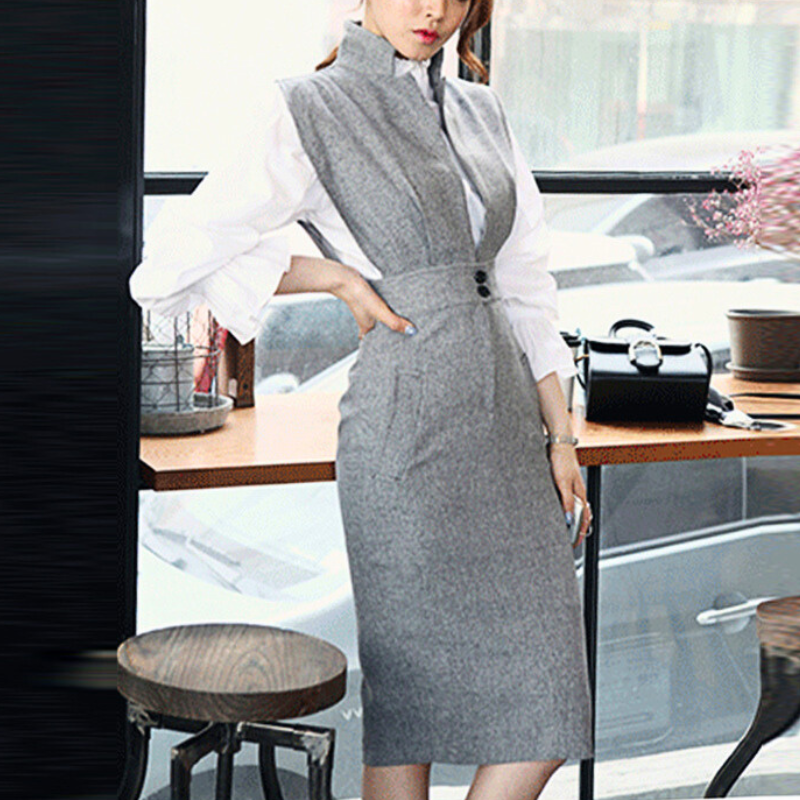 自然な姿勢でグレーのジャンパーワンピを着る女性のナチュラルショット