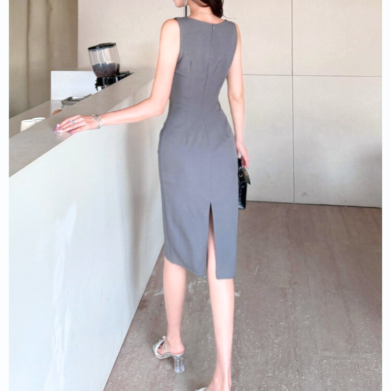 ベルト付きグレーワンピースを着て立つ後ろ姿の女性