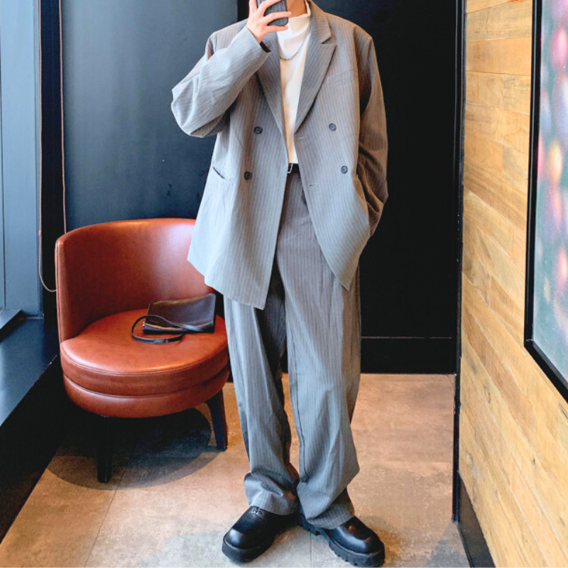 グレージャケットを着て立つ全身コーデ