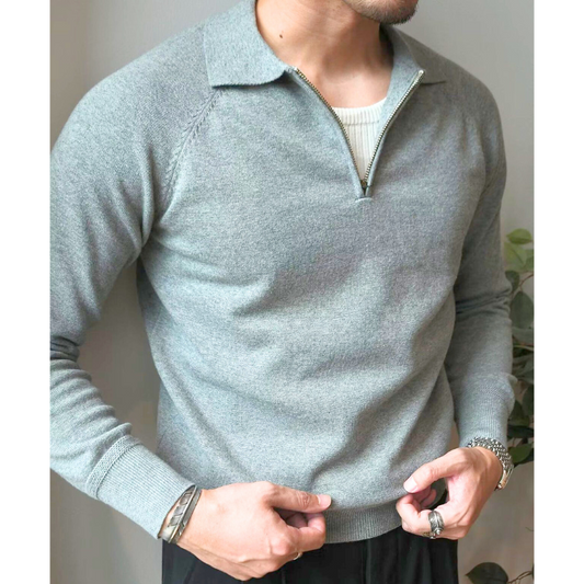 ハーフジップを少し開けたグレーニットセーターの胸元アップ