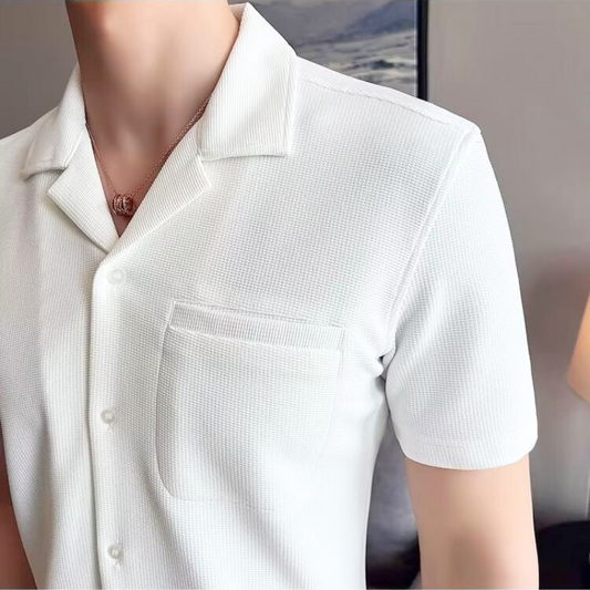 ホワイトの開襟シャツを爽やかに着こなす男性のアップ