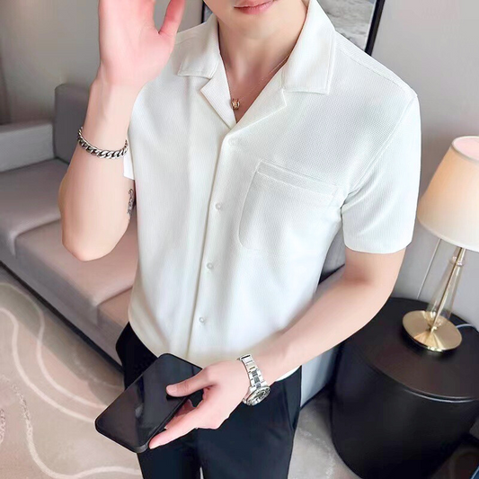 ホワイトのアイスシルク開襟シャツを着てスマホを持つ男性