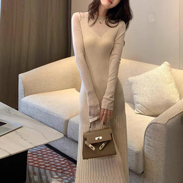 シアースリーブマーメイドニットワンピースを着た女性(アイボリー、手元にバッグ)