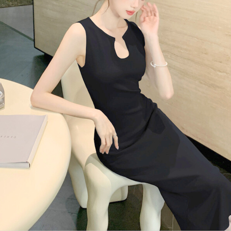 ブラックのワンピで室内に座る女性