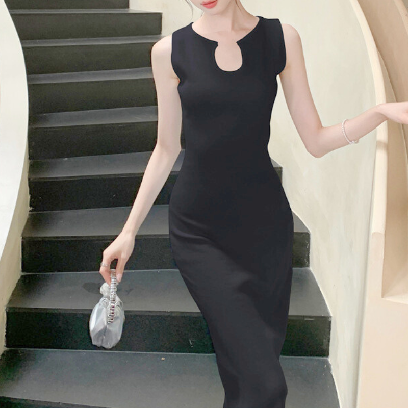 ブラックニットワンピで階段に立つ姿