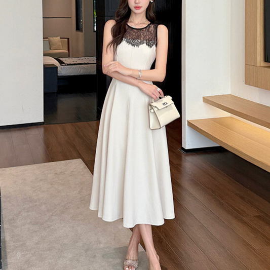 上品なアイボリーワンピースを着て立つ女性。レース切り替えが大人っぽい印象に。