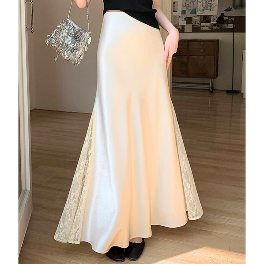ベージュのレース切り替えサテンロングスカートを室内で着用している女性