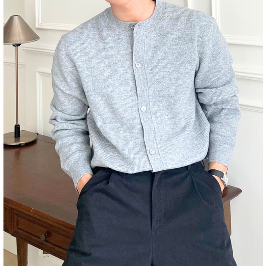 ノーカラーのライトグレーニットカーデを上品に着こなした男性