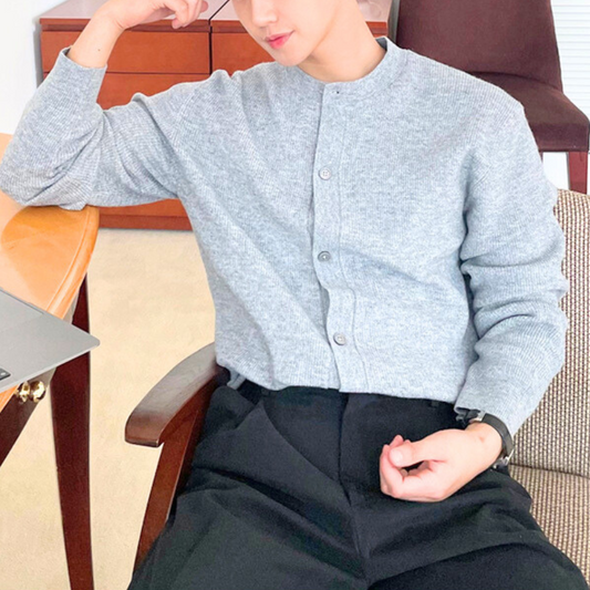 椅子に座ってくつろぐライトグレーニットカーデスタイル