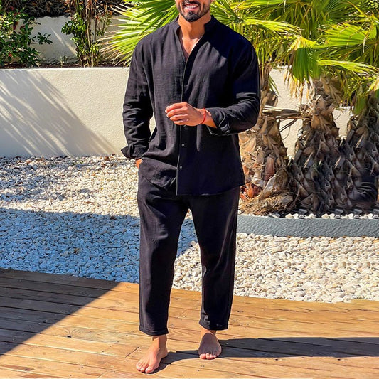 スタンドカラーリネンシャツ×パンツの黒コーデでリラックスする男性