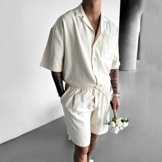 アイボリーのリネン風セットアップを着用した男性の全身ショット(室内・開襟シャツ)