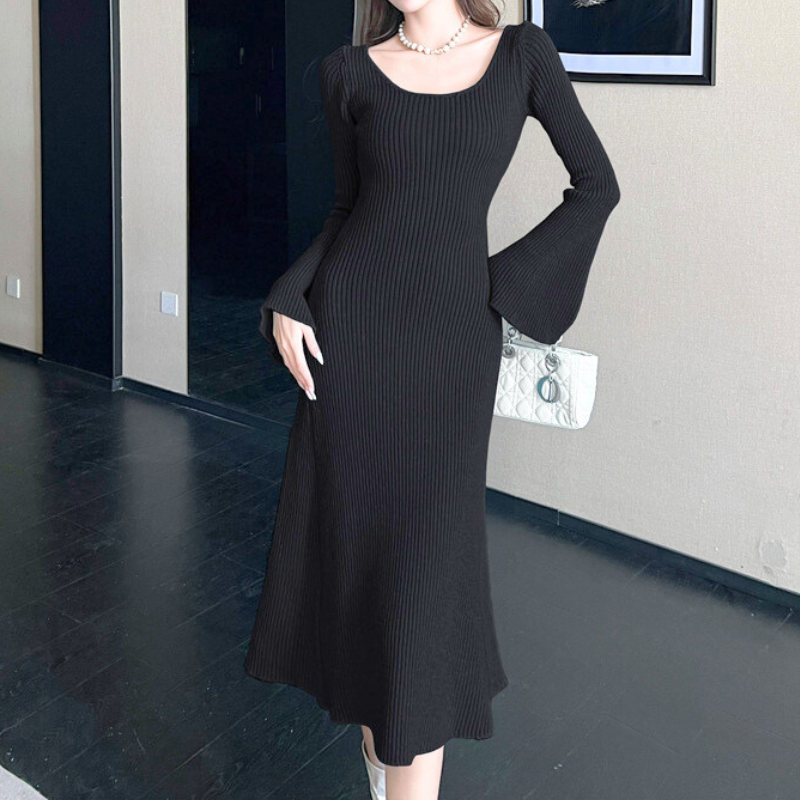 ソファ前でくつろぐ女性のブラックニットワンピースコーデ|上品で大人可愛い雰囲気