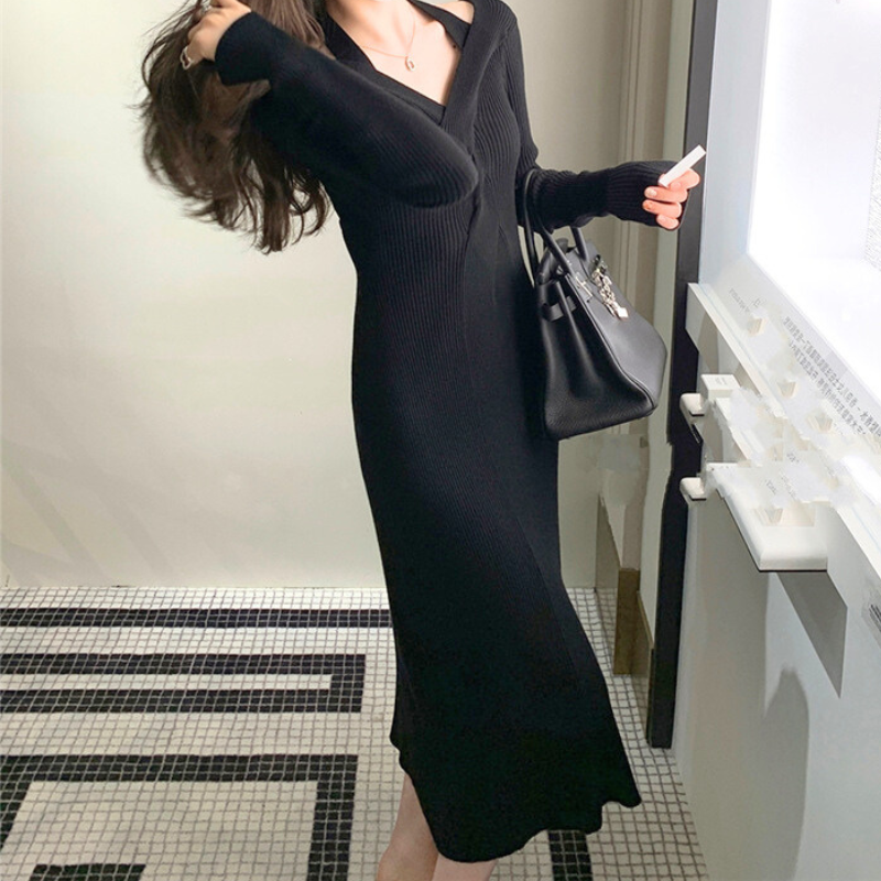 歩いている動きのあるカットで、ブラックワンピースのタイトシルエットとスリットの揺れを強調