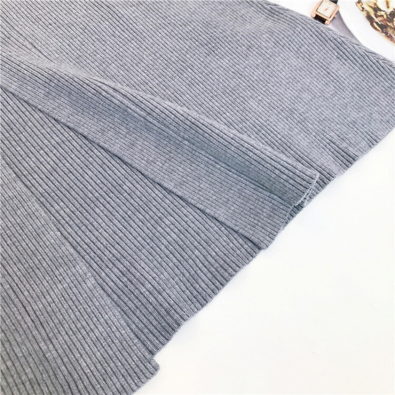 グレーニットワンピースの前面スリット部分をクローズアップし、程よいセクシーさをアピール