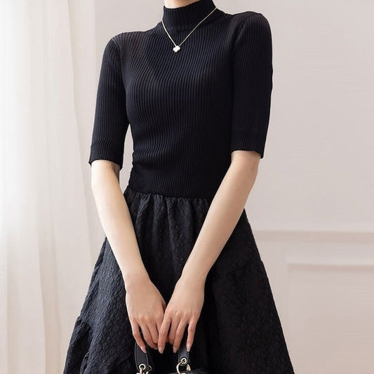 ハイネックと半袖デザインで上品さを演出するブラックのニットトップ部分のアップ