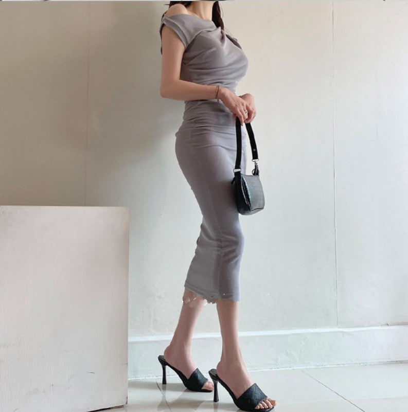 伸縮性のあるカットソー生地がフィットするグレーワンピースを着た女性が歩く様子