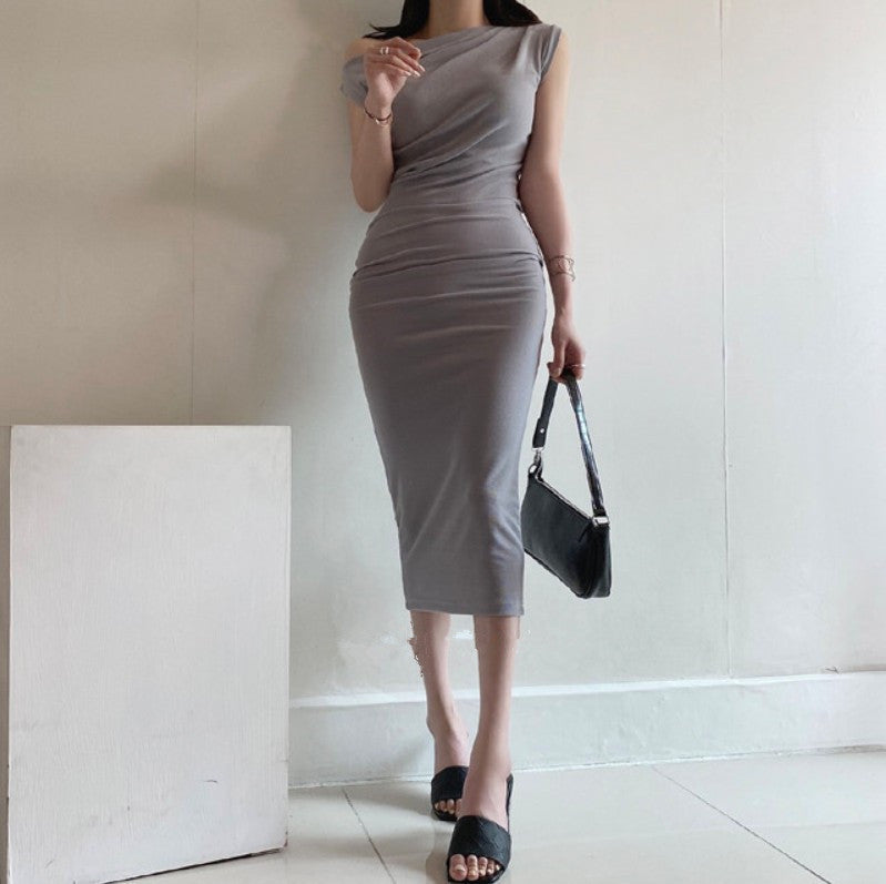 ヒールパンプスを合わせたグレーワンピースのコーディネート例で、脚長効果を狙うスタイリング